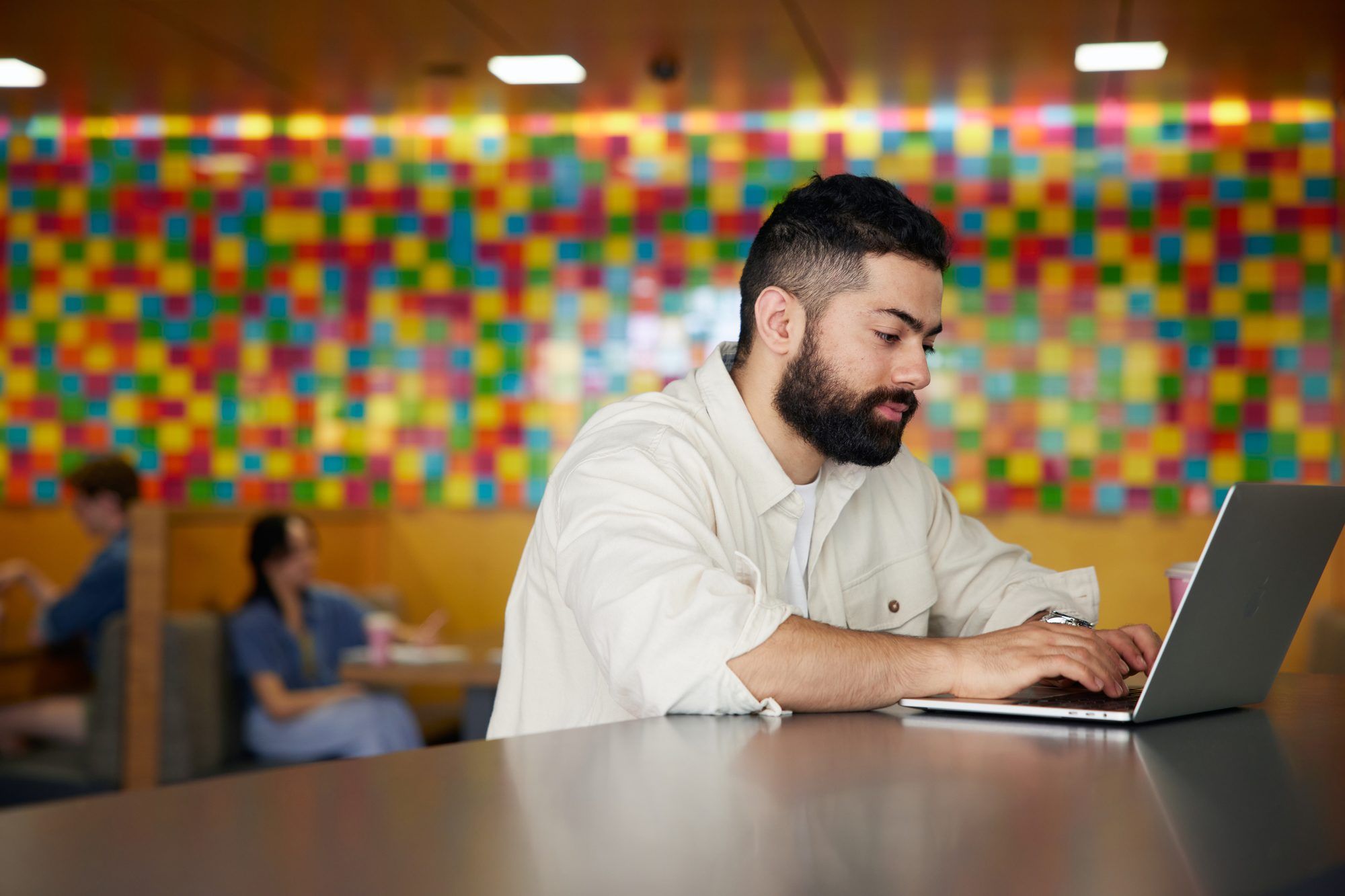 Student sitting in Basement Cafe, working on laptop
