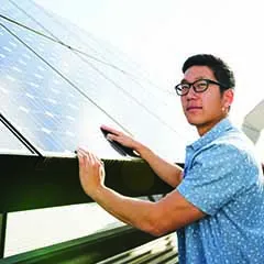 Student touching solar panels