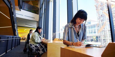 female student sitting in library, studying