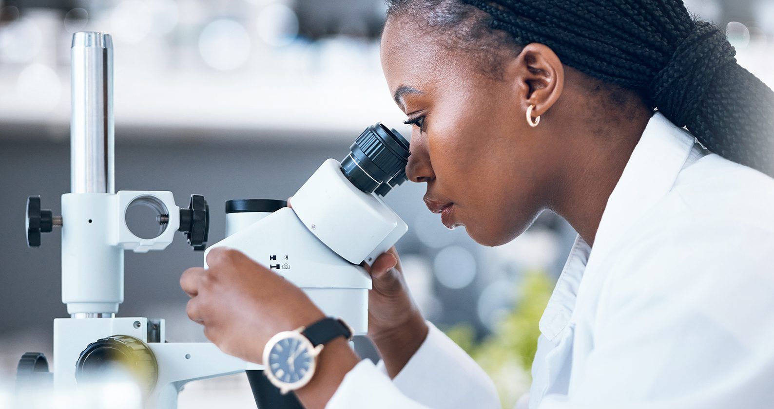 Female biomedical science student looking through a microscope
