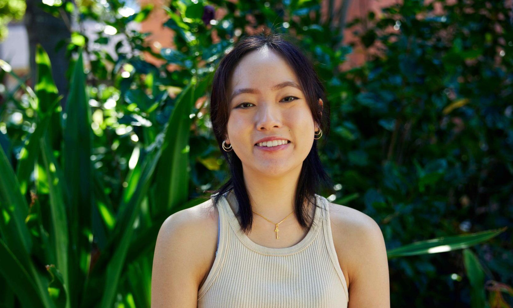 student smiling in front of plants