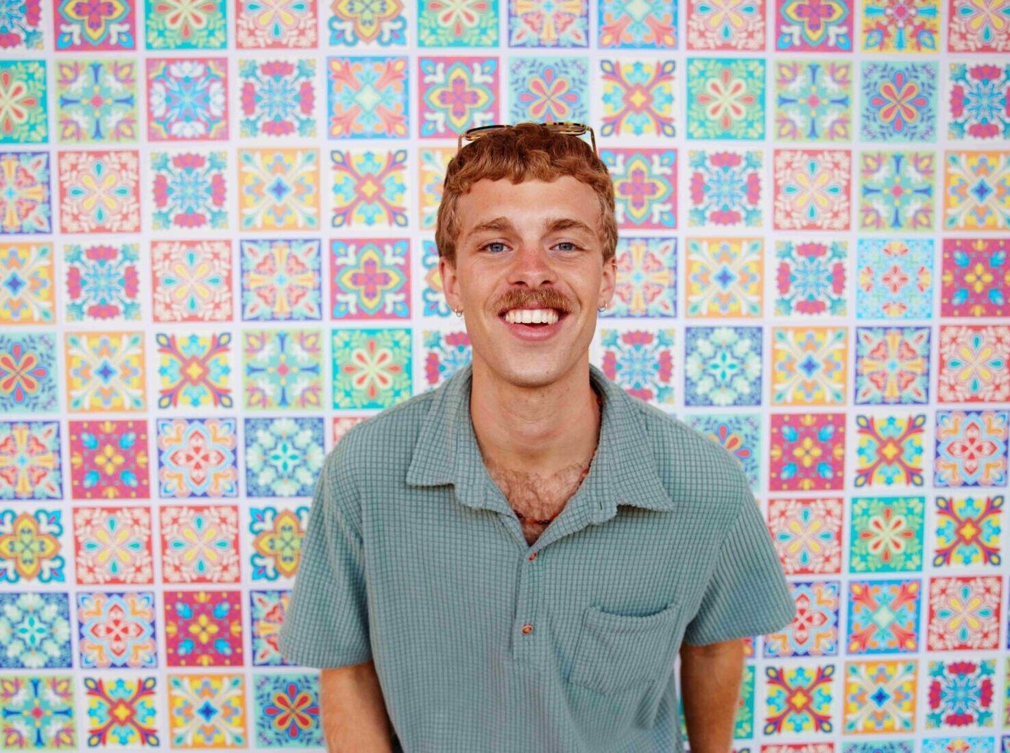 student standing in front of colourful wall