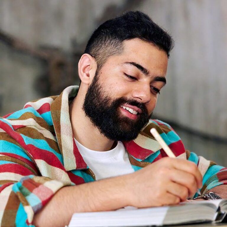mature student with beard writing