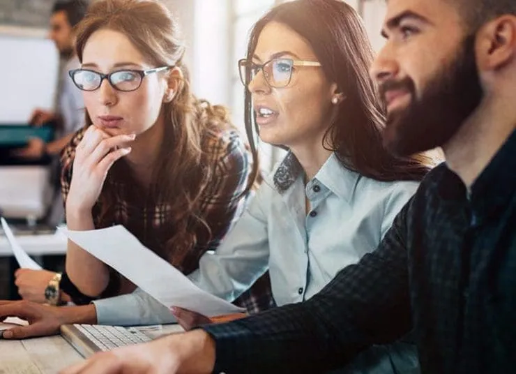 group of office workers looking at a screen