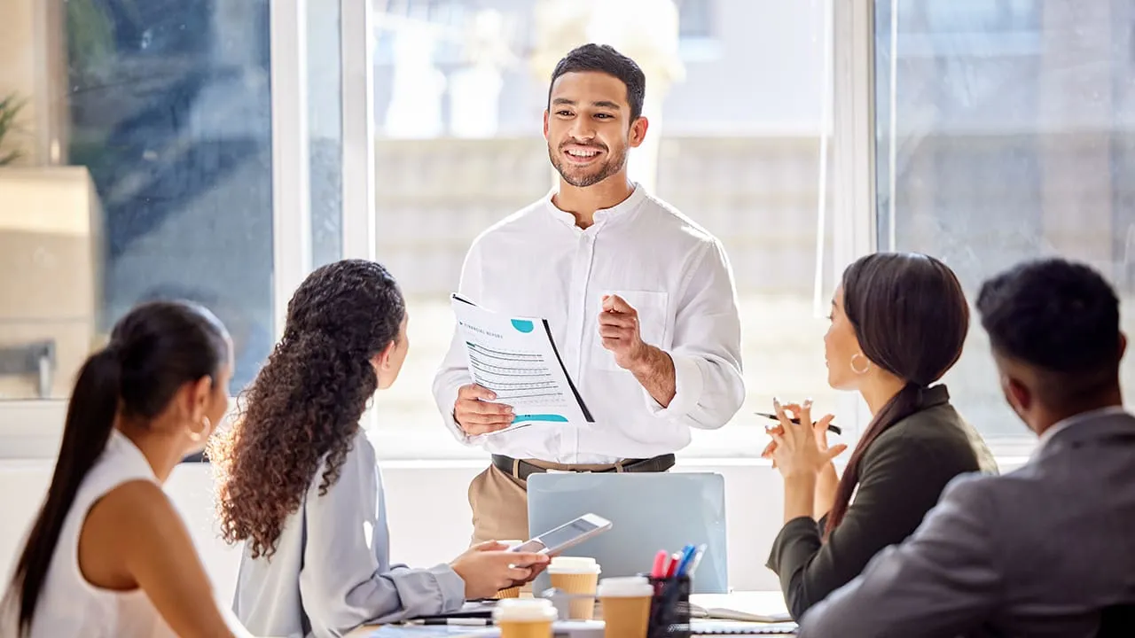 Team meeting with one male professional explaining in front of group