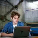 Male student looking at laptop