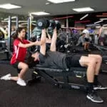 Exercise science students providing exercise advice to patient in a gym