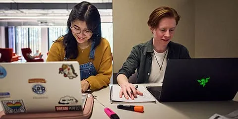Two female students with laptops