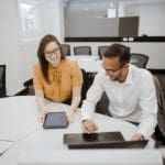 Two young professionals reviewing data on an ipad