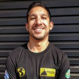 image of smiling curtin student abid iman who is wearing a black t-shirt and is standing against a black background