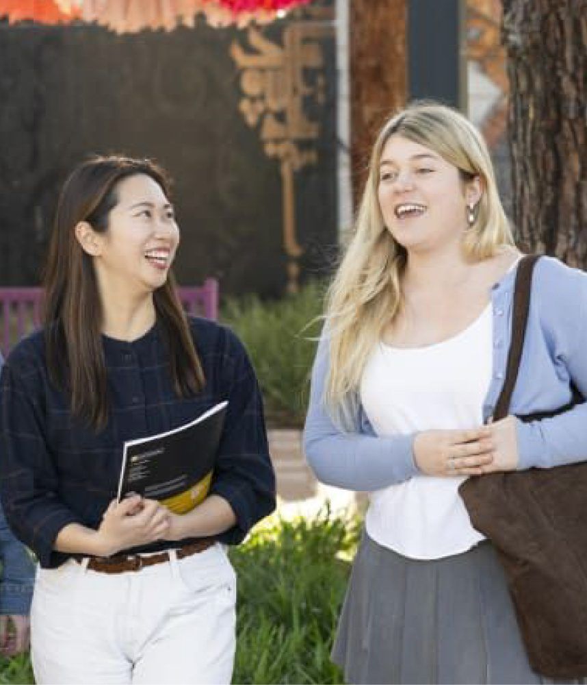 Two female students talking to one another.