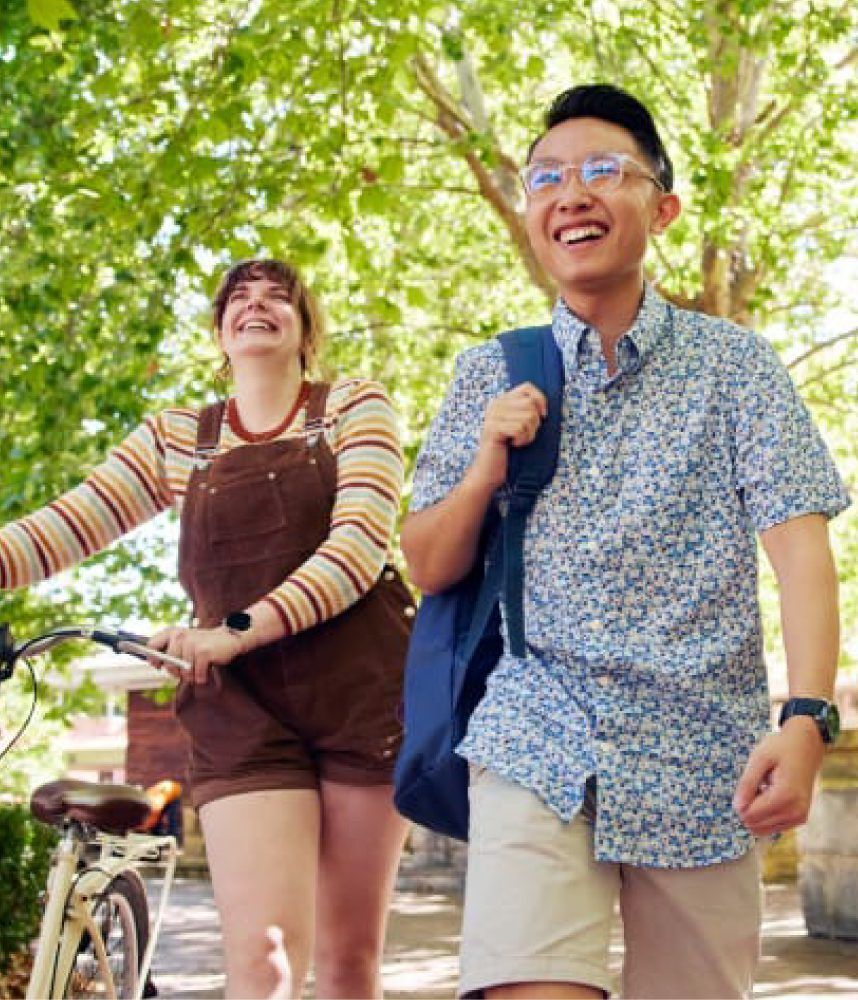 Two happy students walking along the campus grounds.