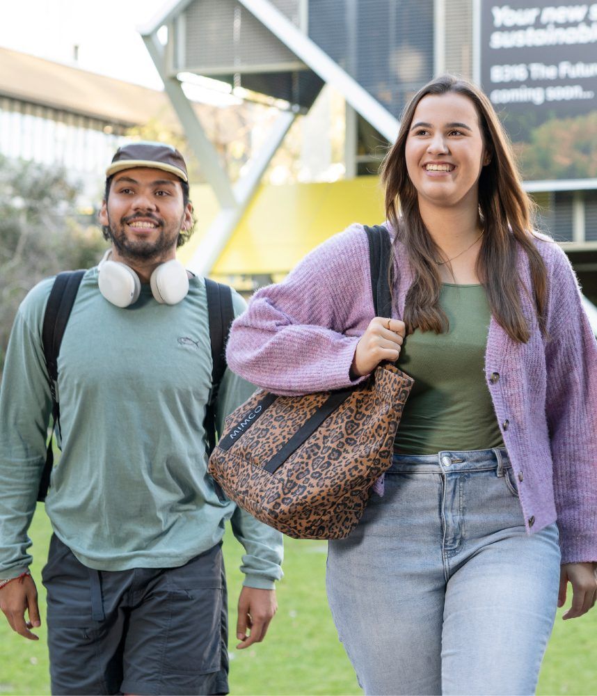 Students walking around in front of the campus building.