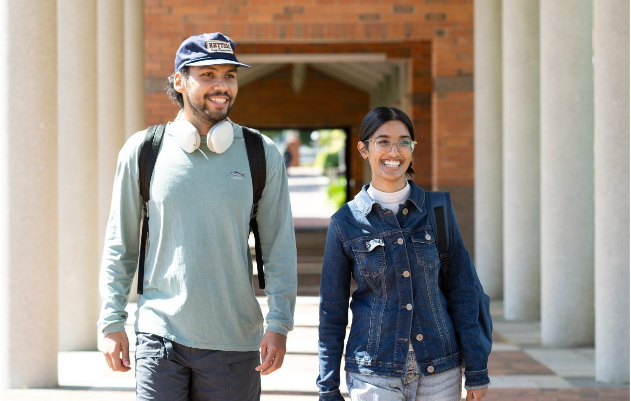 Two students walking around the campus grounds.