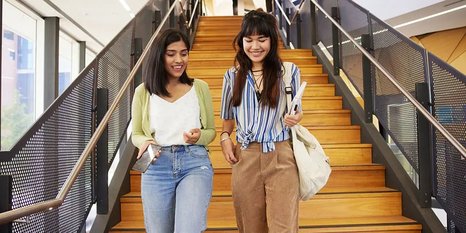Two students walking down the stairs at Curtin Library