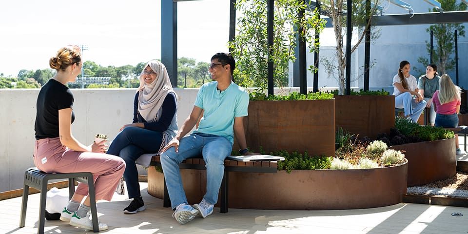 Students sitting and chatting in the outside area of St Catherine's College