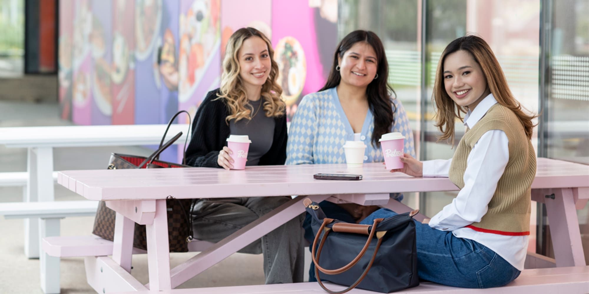 Students sitting at Pretzel's and enjoying a coffee - play video