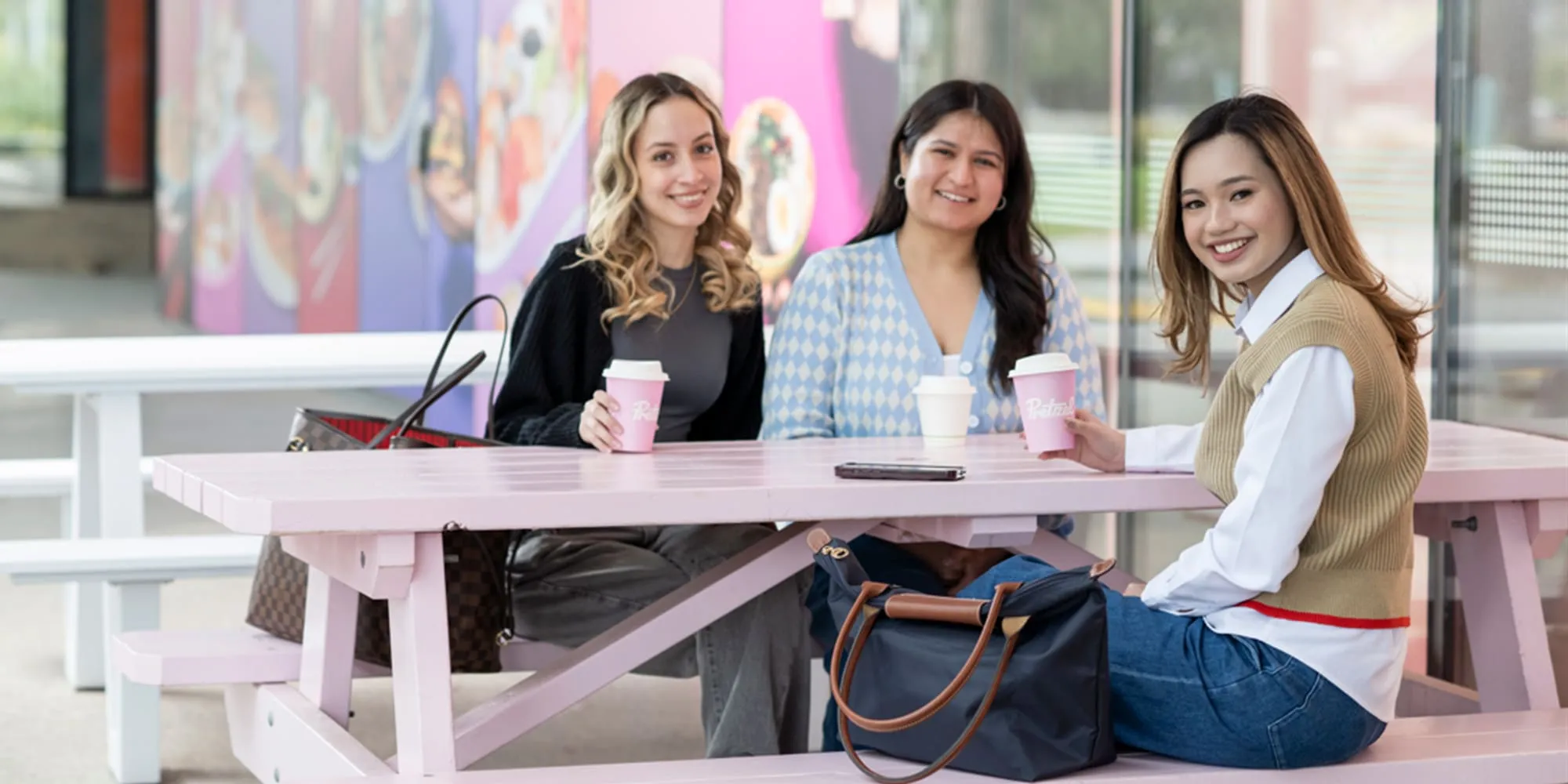 Students sitting at Pretzel's and enjoying a coffee - play video