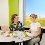 Two students sitting at a table and eating