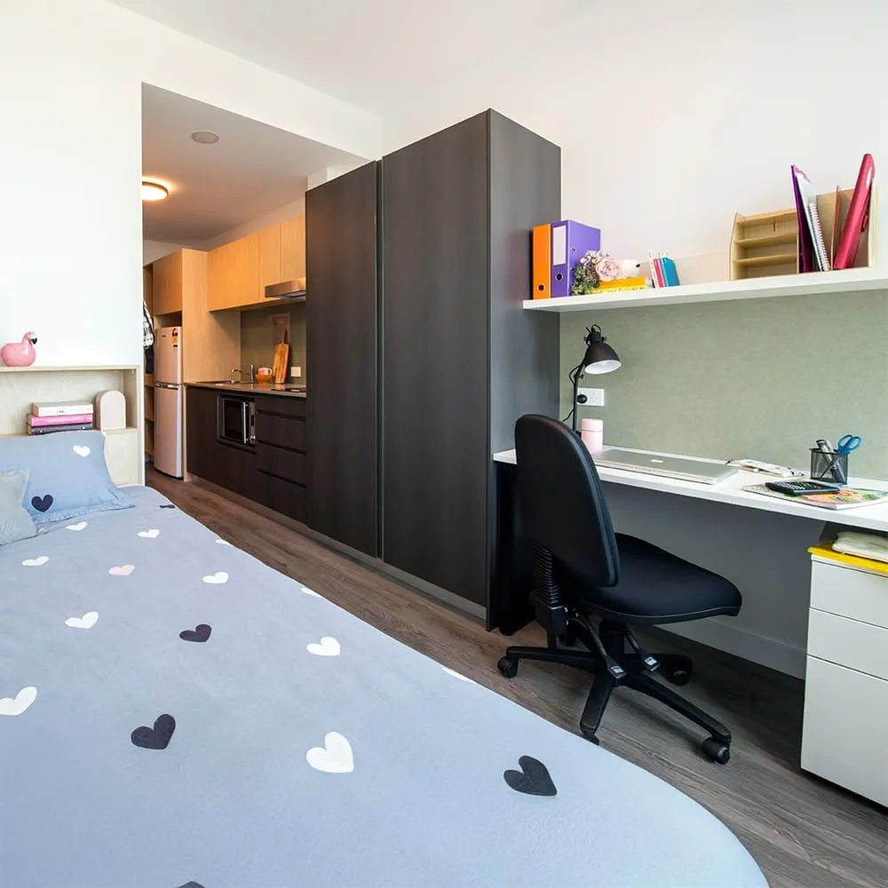 A room in Twin Dolphin Hall featuring a bed, desk and kitchenette in Curtin's Exchange precinct.