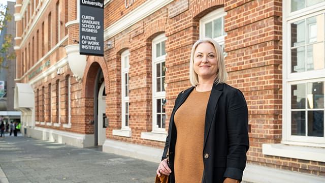 Female MBA scholarship recipient standing outside of Curtin's Business School