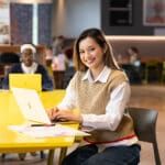 Smiling MBA student looking up from her laptop