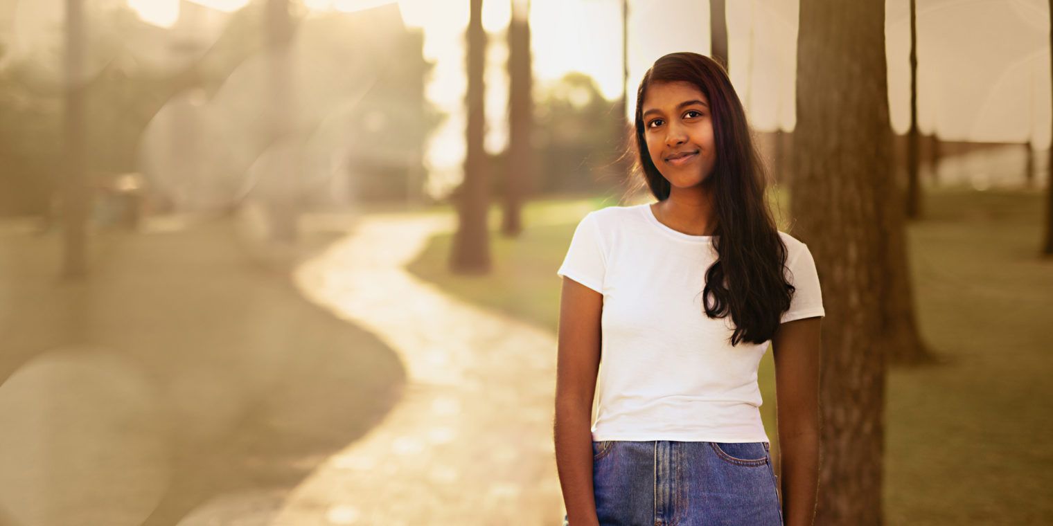 Curtin student, Keana standing under trees, looking at the camera and smiling - play video